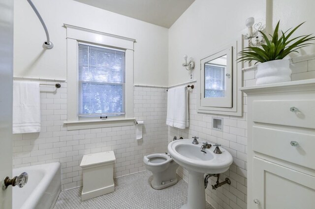 605 E Home Ave, Fresno, CA 93728 - full bathroom with a washtub, tile patterned floors, toilet, and tile walls