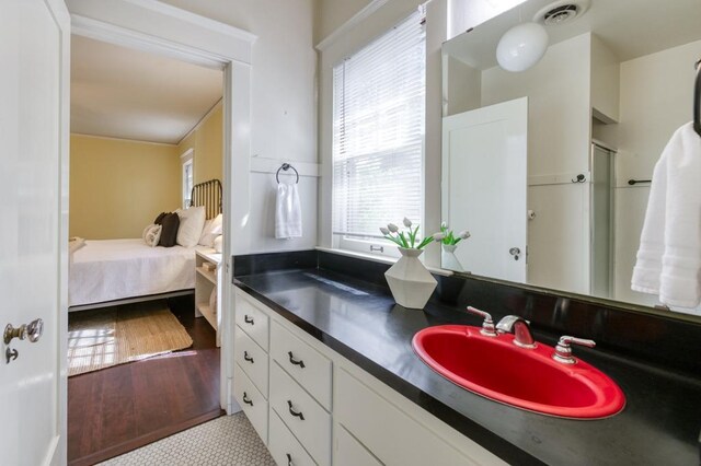 605 E Home Ave, Fresno, CA 93728 - ensuite bathroom featuring visible vents, wood finished floors, a healthy amount of sunlight, and vanity