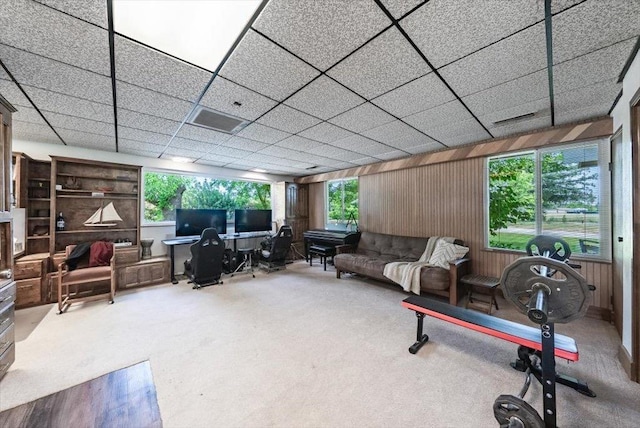 carpeted living room featuring wooden walls and visible vents