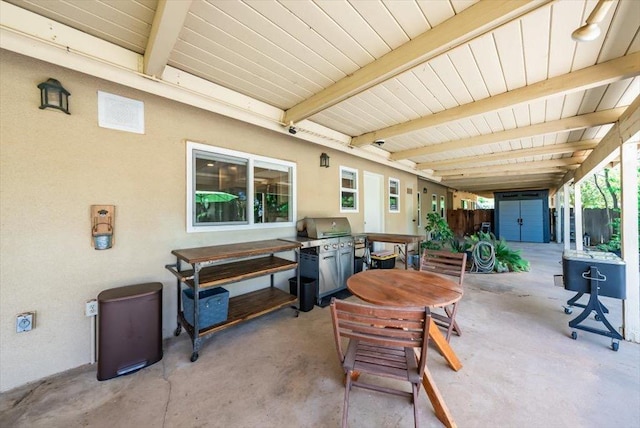 view of patio / terrace featuring grilling area, fence, an outbuilding, a storage shed, and outdoor dining space