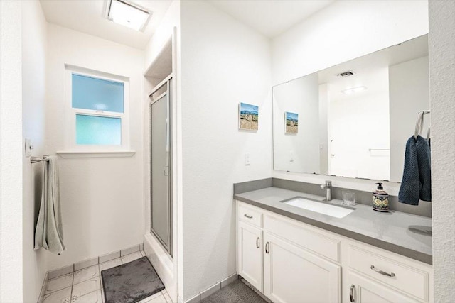 bathroom with a stall shower, visible vents, vanity, and baseboards