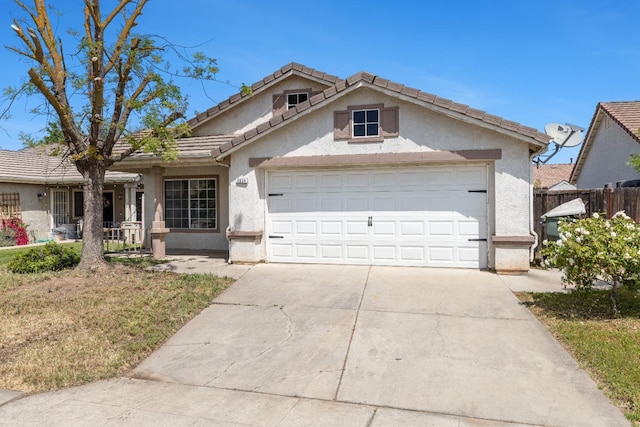 5634 W Donner Ave, Fresno, CA 93722 - view of front of home featuring fence, concrete driveway, stucco siding, and an attached garage