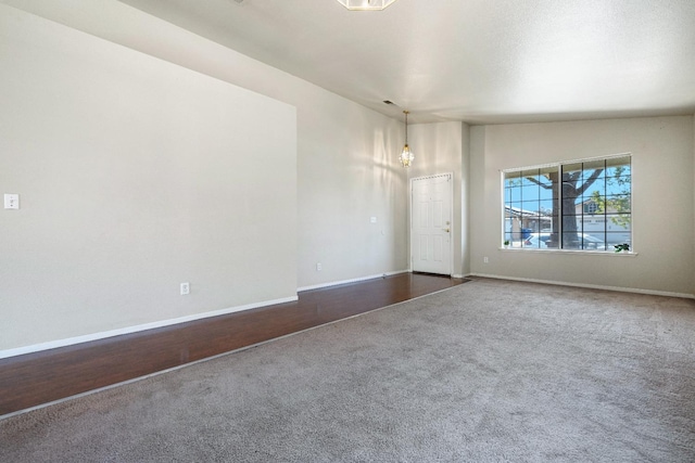 5634 W Donner Ave, Fresno, CA 93722 - empty room featuring dark carpet, an inviting chandelier, and baseboards