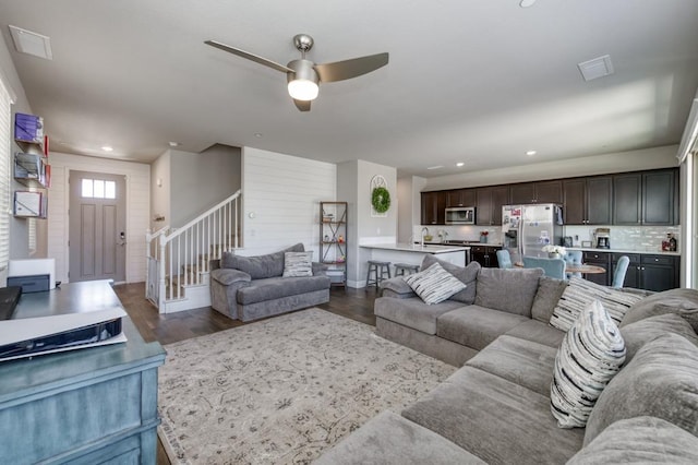 living area with recessed lighting, dark wood-style flooring, ceiling fan, stairs, and visible vents