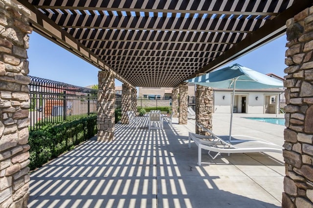 view of patio featuring a pergola, a community pool, and fence