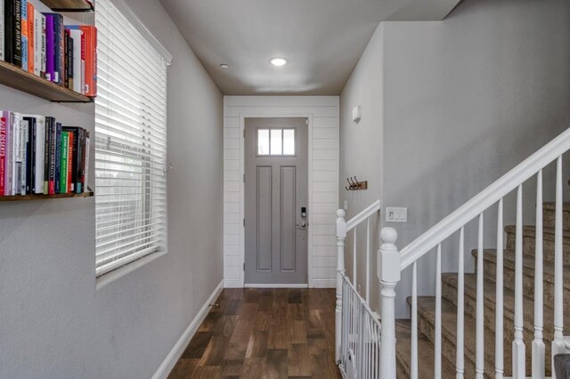 foyer entrance with wood finished floors, stairs, and baseboards