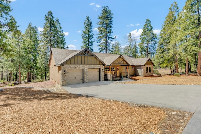 42596 Garnet Ln, Shaver Lake, CA 93664 - view of front facade with board and batten siding, a garage, concrete driveway, a porch, and stone siding