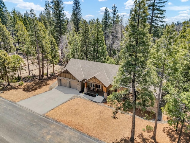 42596 Garnet Ln, Shaver Lake, CA 93664 - view of front facade featuring board and batten siding, an attached garage, covered porch, a shingled roof, and concrete driveway