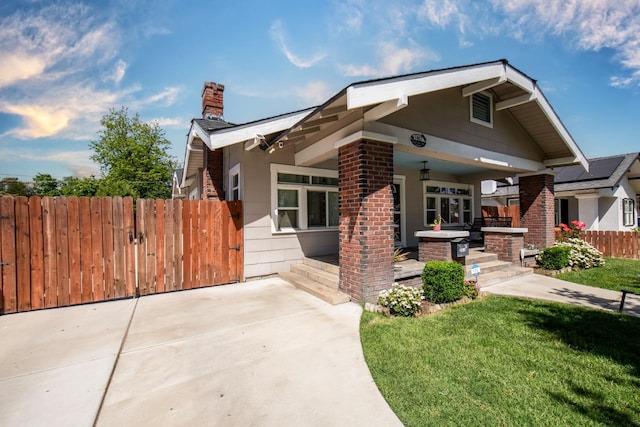 view of front of home with fence, a chimney, a front yard, and a patio