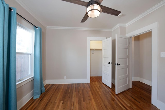 unfurnished bedroom featuring baseboards, wood finished floors, and crown molding