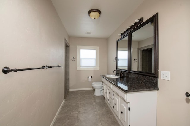 bathroom featuring tile patterned floors, toilet, vanity, baseboards, and visible vents