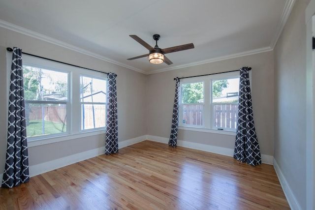 unfurnished room featuring wood finished floors, a healthy amount of sunlight, and ornamental molding