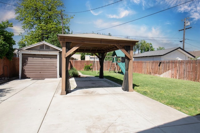 exterior space featuring driveway, an outdoor structure, a playground, a detached garage, and a fenced backyard