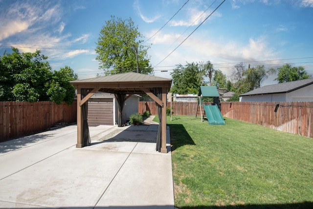 view of yard featuring a patio, a fenced backyard, driveway, a playground, and a gazebo