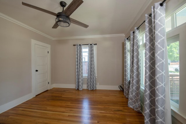 unfurnished room with crown molding, a ceiling fan, wood finished floors, and baseboards