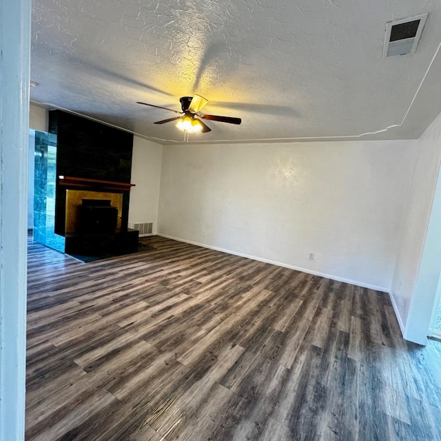 201 Walnut St, Madera, CA 93637 - unfurnished living room with wood finished floors, a fireplace, a ceiling fan, baseboards, and a textured ceiling