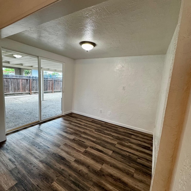 201 Walnut St, Madera, CA 93637 - spare room with a textured wall, dark wood-type flooring, a textured ceiling, and baseboards