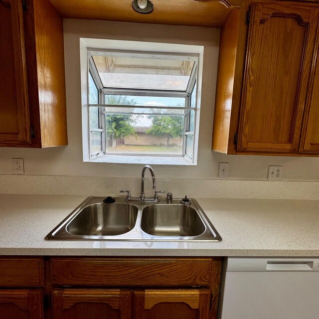 201 Walnut St, Madera, CA 93637 - kitchen featuring dishwasher, a sink, light countertops, and brown cabinetry
