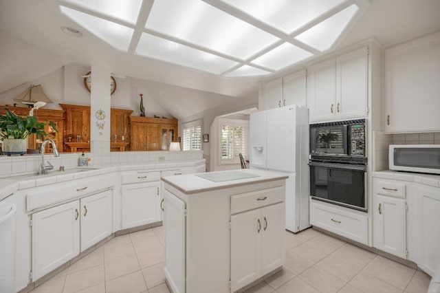 2727 W Bluff Ave Unit 136, Fresno, CA 93711 - kitchen featuring black appliances, decorative backsplash, a kitchen island, and a sink