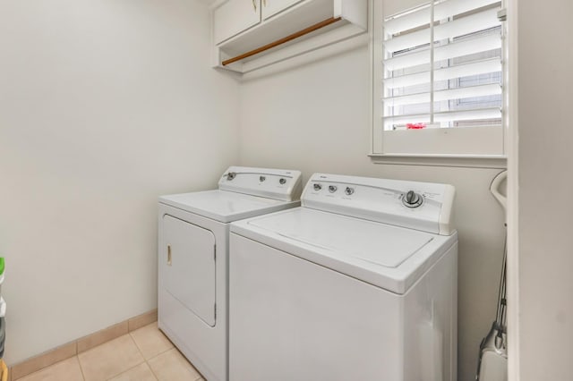 2727 W Bluff Ave Unit 136, Fresno, CA 93711 - clothes washing area featuring baseboards, cabinet space, washing machine and clothes dryer, and light tile patterned flooring