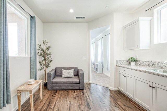sitting room with dark wood-style flooring, visible vents, recessed lighting, and baseboards