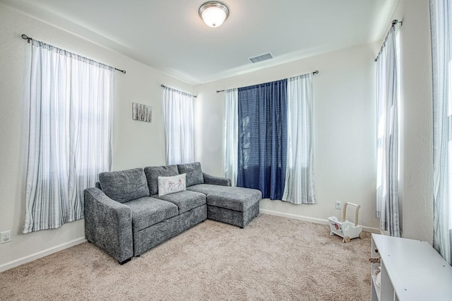carpeted living area with visible vents and baseboards