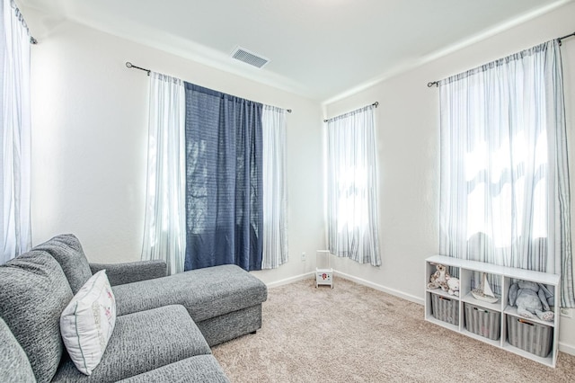 living area featuring carpet flooring, visible vents, and baseboards