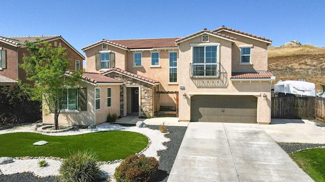 mediterranean / spanish house with a tile roof, a garage, stucco siding, and fence