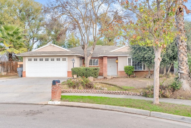 ranch-style home with concrete driveway, an attached garage, brick siding, and fence