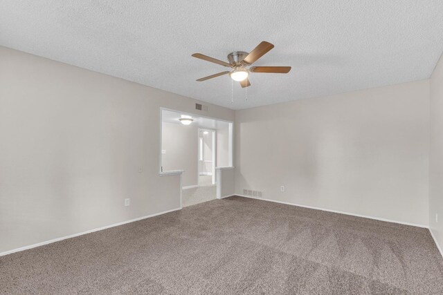 carpeted spare room featuring baseboards, visible vents, ceiling fan, and a textured ceiling