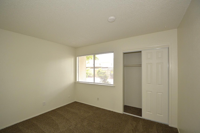 4765 N Cedar Ave Unit 105, Fresno, CA 93726 - unfurnished bedroom featuring dark carpet, a closet, and a textured ceiling