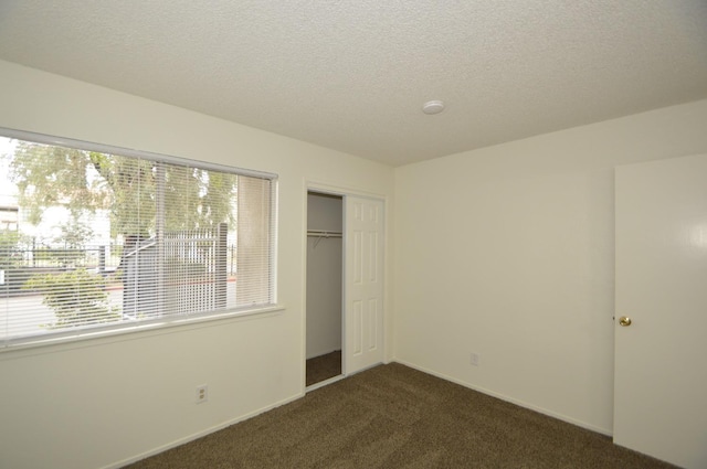 4765 N Cedar Ave Unit 105, Fresno, CA 93726 - unfurnished bedroom featuring dark carpet, a closet, and a textured ceiling
