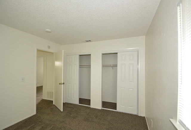 4765 N Cedar Ave Unit 105, Fresno, CA 93726 - unfurnished bedroom featuring multiple closets, dark colored carpet, and a textured ceiling