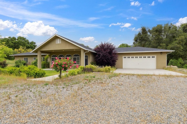 ranch-style home with stucco siding, gravel driveway, and an attached garage
