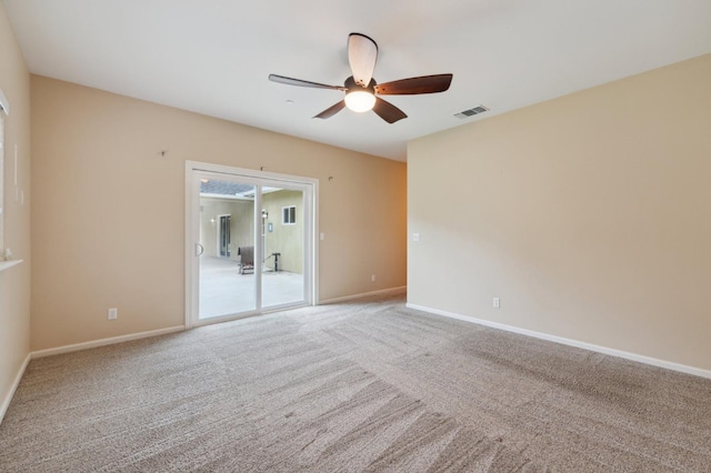 carpeted spare room with ceiling fan, visible vents, and baseboards