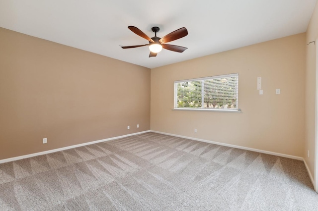 unfurnished room with baseboards, ceiling fan, and light colored carpet