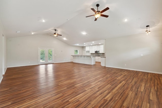 unfurnished living room featuring wood finished floors, ceiling fan, vaulted ceiling, and baseboards