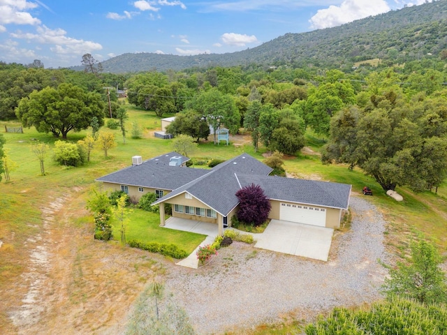 drone / aerial view with a mountain view and a view of trees