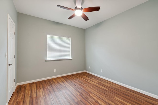 empty room with baseboards, wood finished floors, and ceiling fan