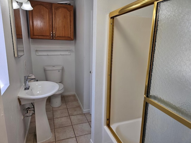 bathroom with baseboards, toilet, and tile patterned flooring