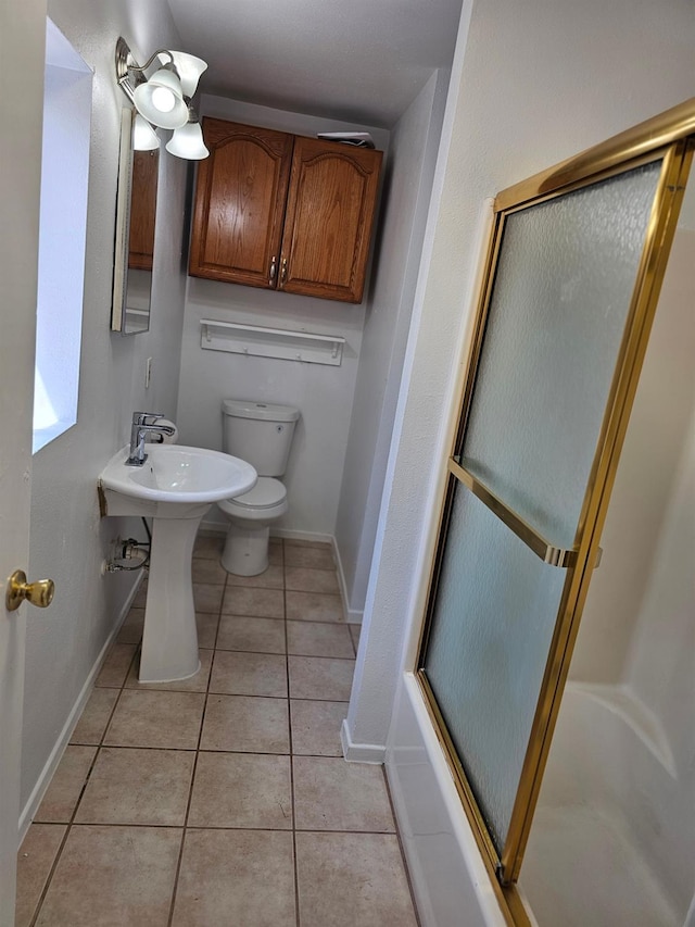 bathroom featuring tile patterned floors, toilet, and baseboards