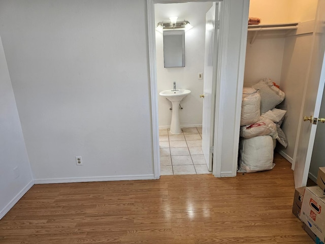 bathroom featuring a sink, wood finished floors, and baseboards