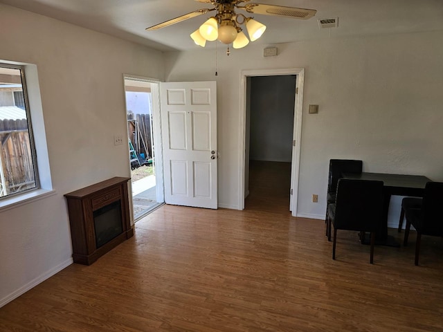 living room with wood finished floors, visible vents, ceiling fan, and plenty of natural light