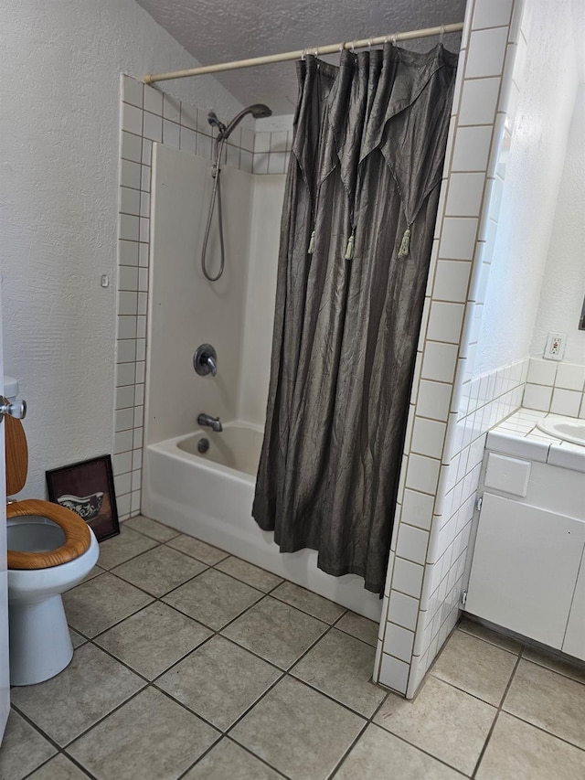 bathroom featuring tile patterned flooring, shower / bath combo, toilet, a textured wall, and vanity