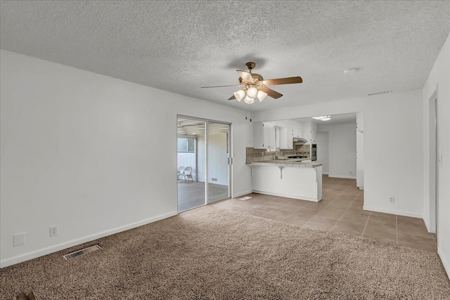 30 S Cambridge Dr, Lemoore, CA 93245 - unfurnished living room with a ceiling fan, baseboards, light carpet, a textured ceiling, and light tile patterned floors