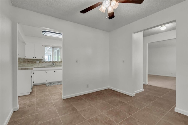 30 S Cambridge Dr, Lemoore, CA 93245 - spare room with a ceiling fan, a textured ceiling, light tile patterned floors, a sink, and baseboards