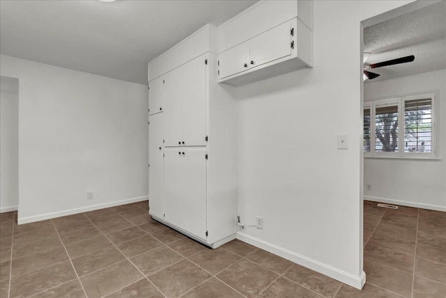 30 S Cambridge Dr, Lemoore, CA 93245 - interior space featuring a ceiling fan, tile patterned flooring, white cabinets, baseboards, and a textured ceiling