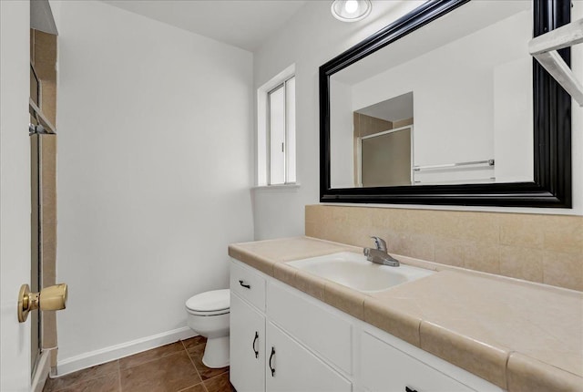 30 S Cambridge Dr, Lemoore, CA 93245 - bathroom featuring toilet, a shower stall, vanity, baseboards, and tasteful backsplash