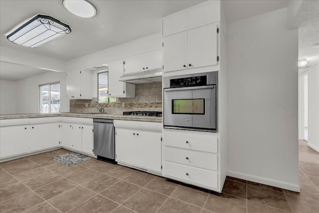 30 S Cambridge Dr, Lemoore, CA 93245 - kitchen with appliances with stainless steel finishes, under cabinet range hood, decorative backsplash, and white cabinets