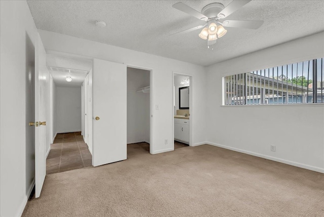 30 S Cambridge Dr, Lemoore, CA 93245 - unfurnished bedroom featuring light colored carpet, a textured ceiling, attic access, a closet, and a walk in closet